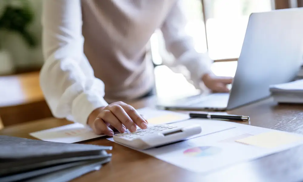 woman using calculator on desk
